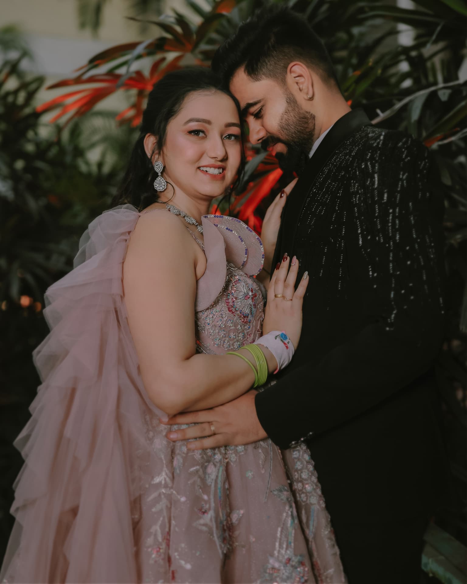 Anand and Soumya embracing among red foliage at their Gurugram engagement, Club Patio South City